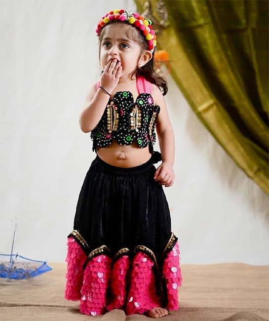 Baby girl Navratri Garba look in black and pink lehenga choli with mirror work blouse.