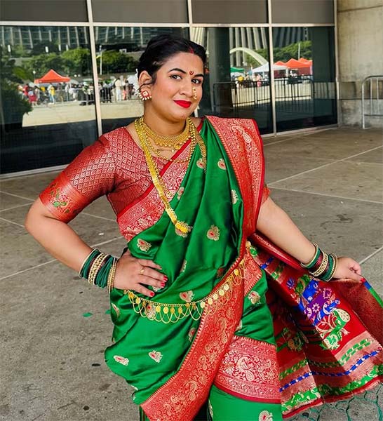 Woman in green Nauvari saree with red blouse and traditional Maharashtrian jewellery