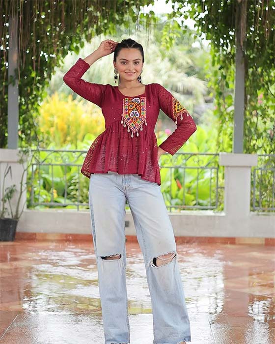 Girl wearing maroon embroidered kurti with ripped jeans for Navratri fusion look