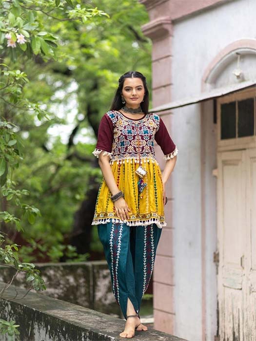 Girl in yellow kutchi embroidered kurti with teal dhoti pants for Navratri Garba look