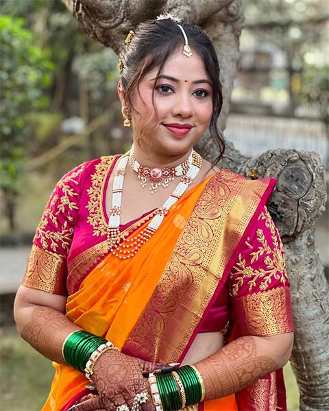 Bride in orange Nauvari saree with pink blouse and traditional jewellery