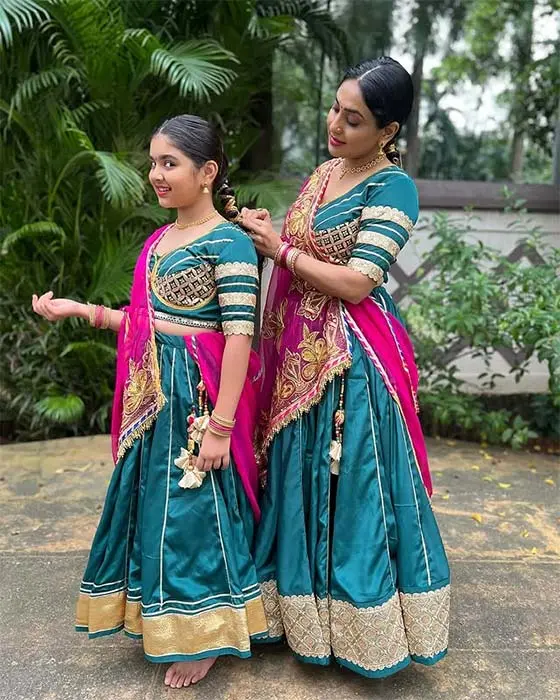 Mom and daughter in matching teal and pink lehenga choli for traditional Navratri Garba look.