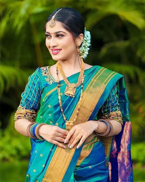 Bride in peacock blue and green saree with gold temple jewellery