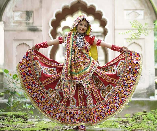 Woman in traditional Gujarati red chaniya choli with embroidery and mirror work for Navratri